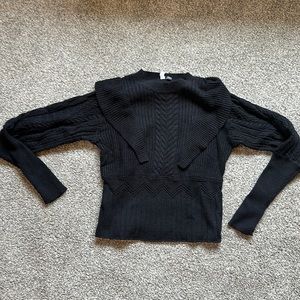 Black fitted sweater with accenting ruffles.